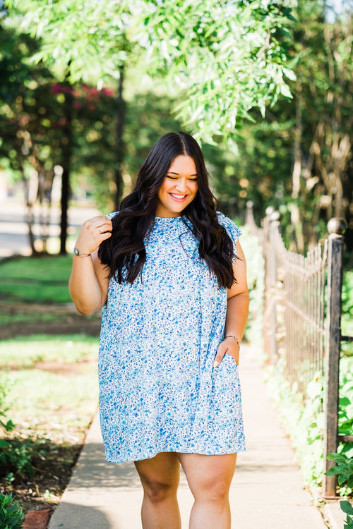tiered pocket dress in blue and teal small floral on white base featuring pockets plus size model