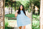 misty bd tiered pocket dress in blue and teal small floral on white base plus size holding left side of the dress
