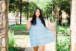 misty bd tiered pocket dress in blue and teal small floral on white base plus size holding left side of the dress