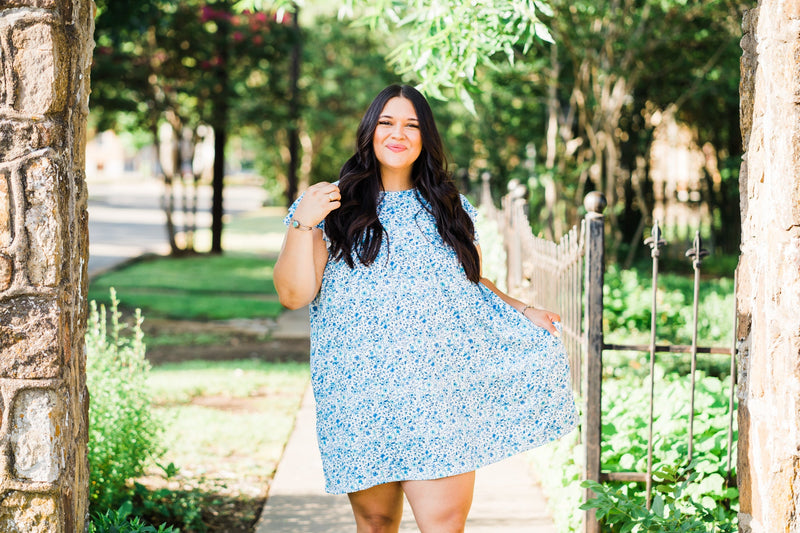 misty bd tiered pocket dress in blue and teal small floral on white base plus size holding left side of the dress