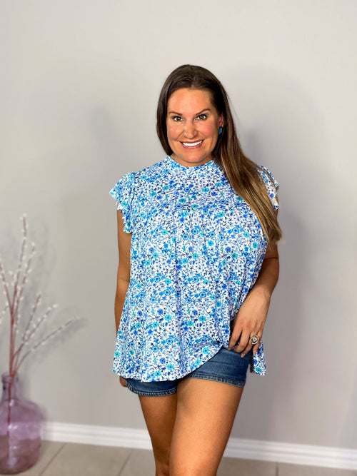 tiered ruffle sleeve top in blue and teal small on white base floral front view